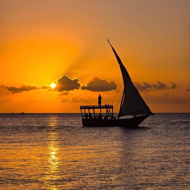 A dhow sailing across a golden sunset off Nungwi, Zanzibar